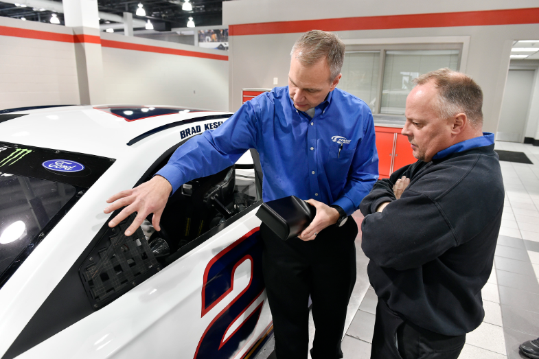 Production manager Matt Gimbel discusses the installation
of a 3D printed rearview mirror housing.