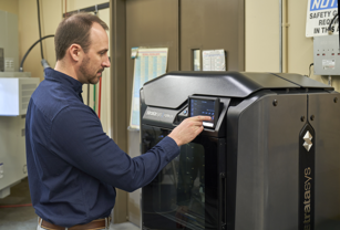 Engineer standing next to a Stratasys printer.