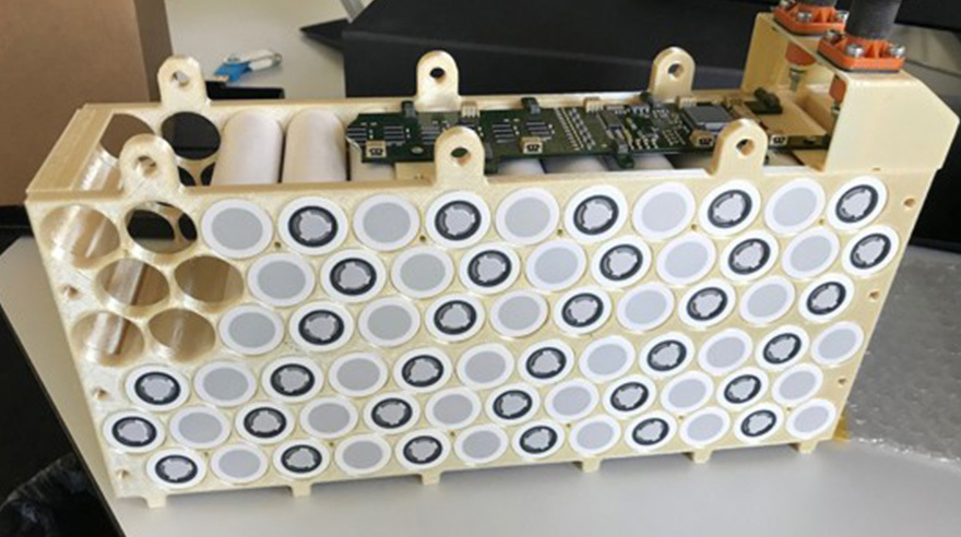 The completed battery case printed with ULTEM™ 9085 resin shown with some of the battery cells installed.